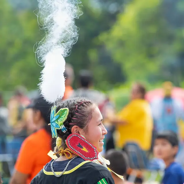 Young dancer in regalia at a community gathering