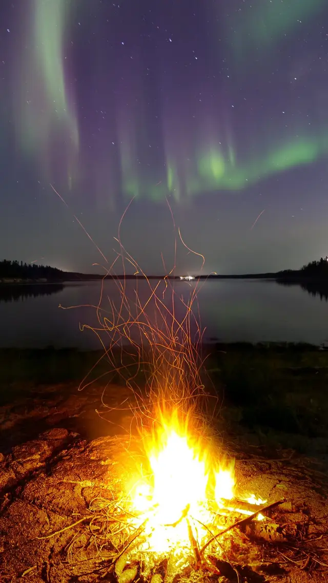 Aurora and campfire by the lake